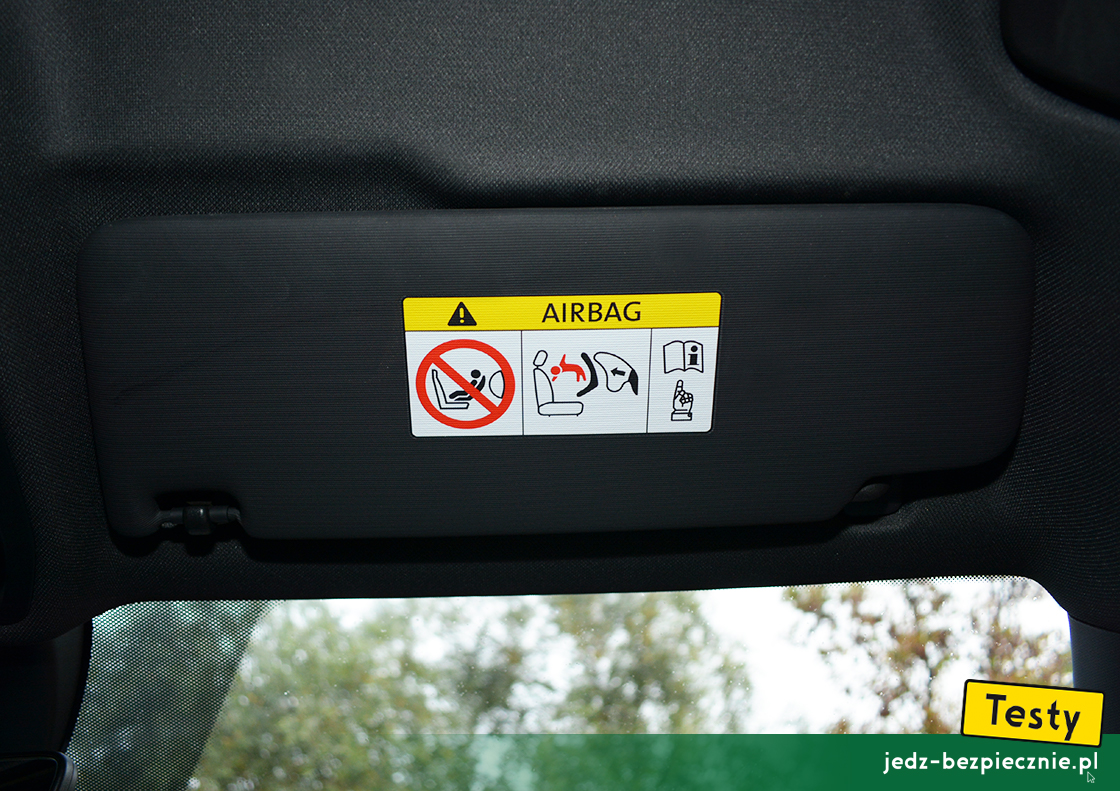 Testy - Cupra Leon e-Hybrid hatchback - ostrzeżenie na osłonie przeciwsłonecznej pasażera, fotelik tyłem do kierunku jazdy